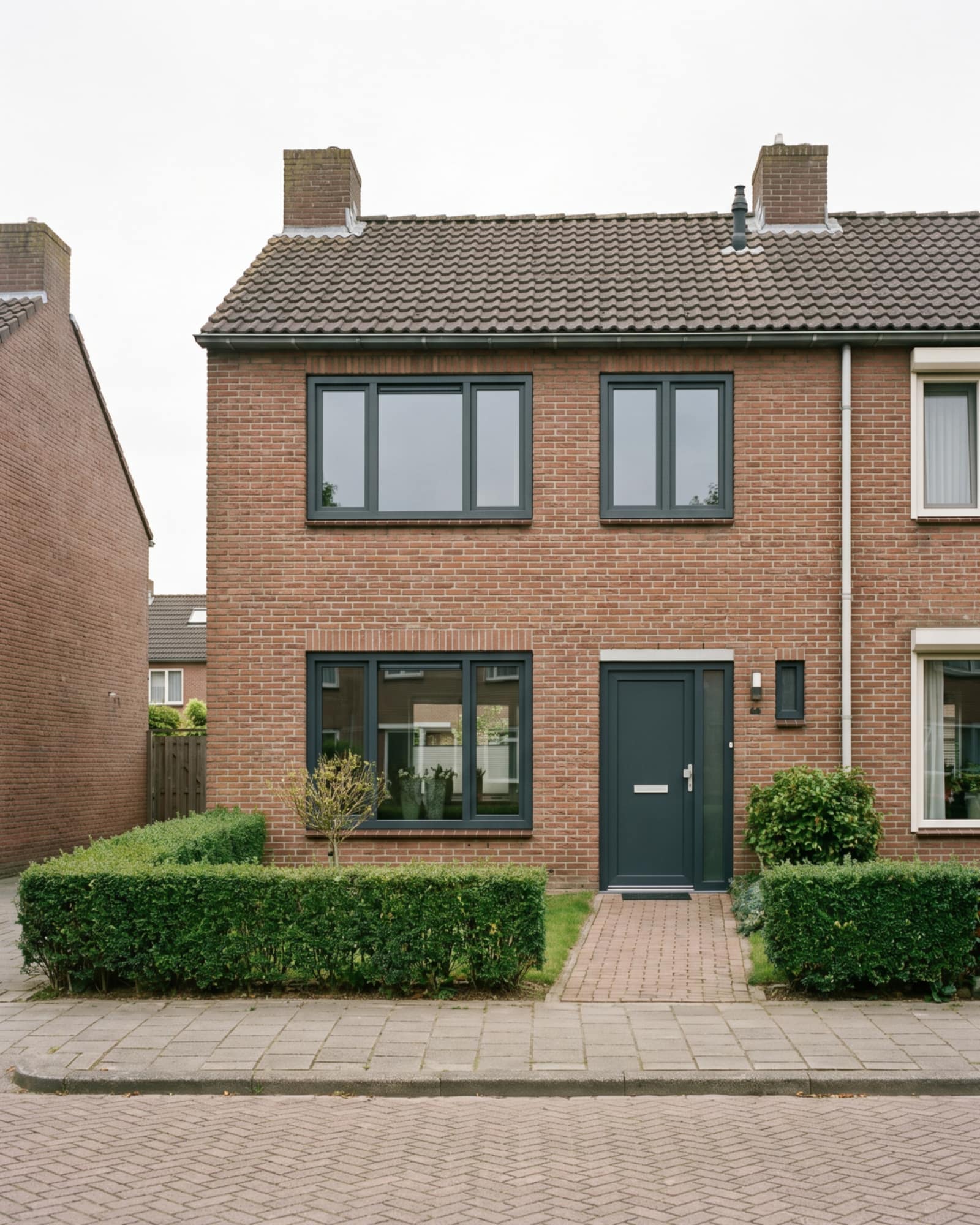 Voorgevel van een Nederlandse rijtjeswoning met nieuwe kozijnen